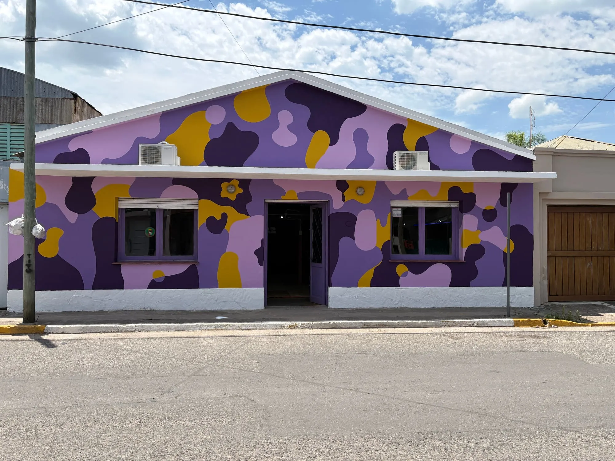 Frente de academia de baile con mural violeta y amarillo