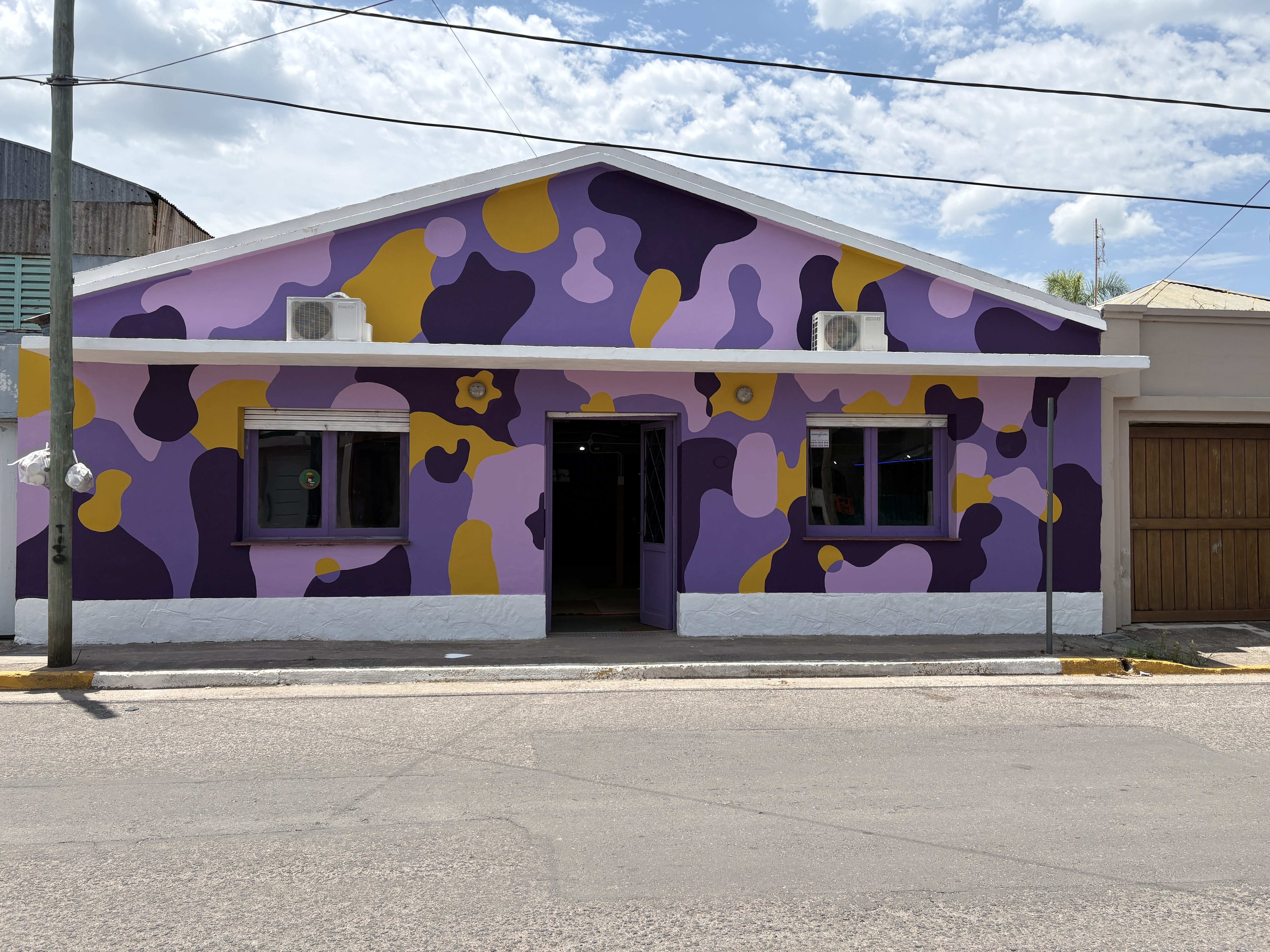 Frente de academia de baile con mural violeta y amarillo