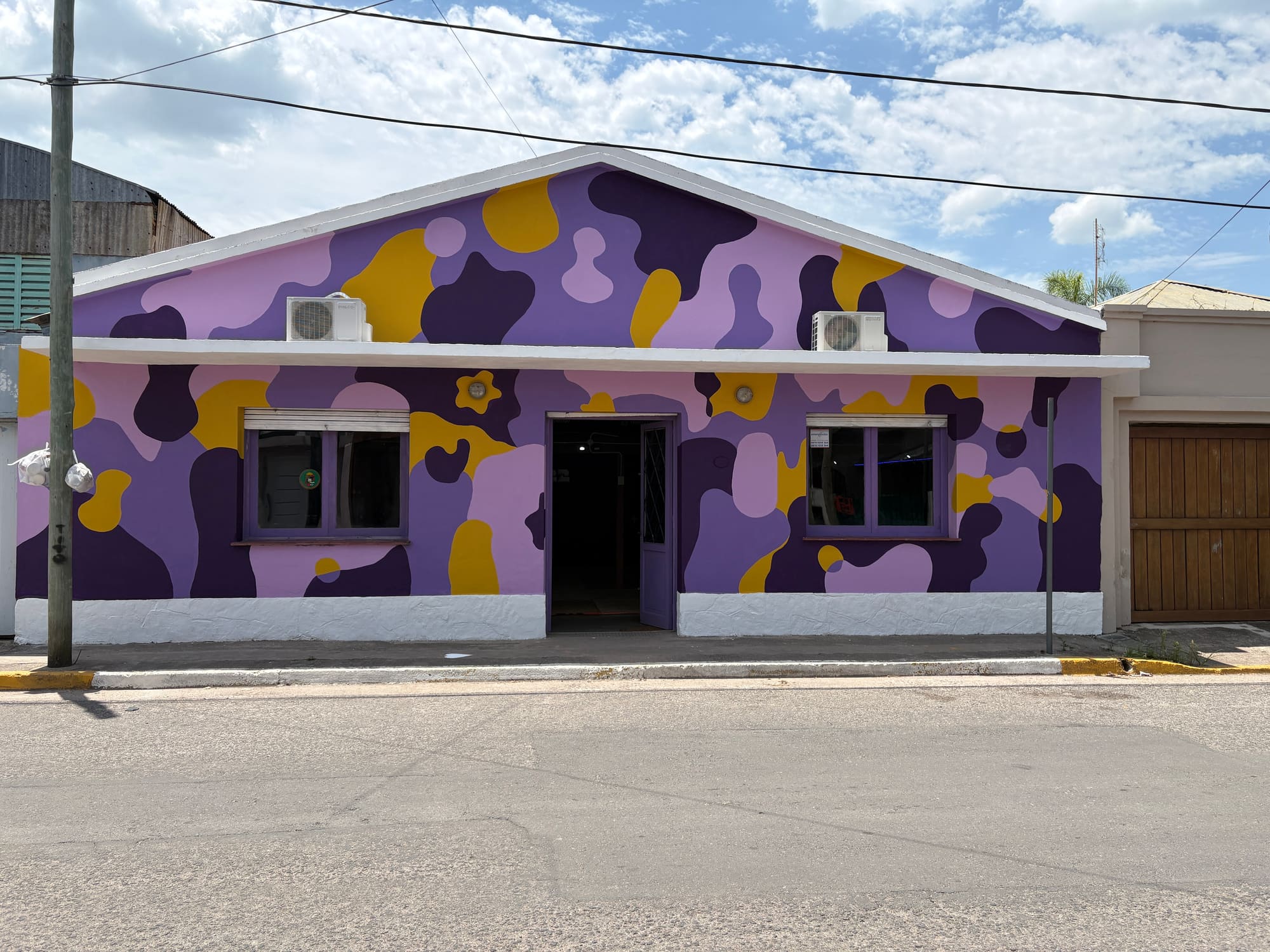 Frente de academia de baile con mural violeta y amarillo